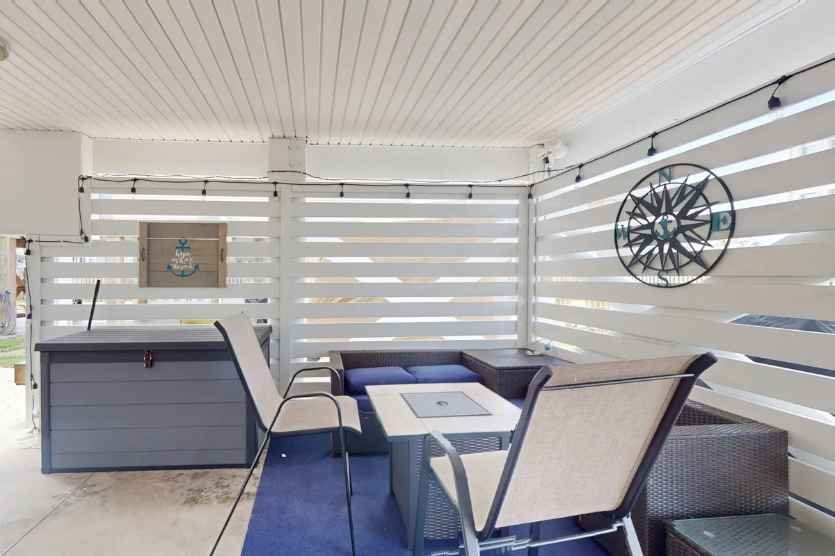 This image shows a welcoming outdoor seating area with comfortable furniture, a decorative wall compass, and a storage chest. It's designed for relaxation, socializing, and enjoying the fresh air in a private setting, resonating with the idea of multiple private porches for unwinding or sharing moments with friends and family.