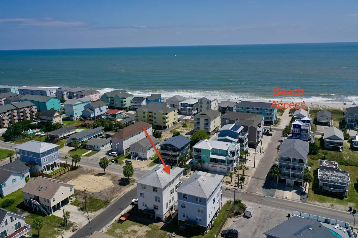 This exterior shot captures an ocean view with nearby homes and direct beach access, creating a cheerful and vacation-like mood. The setting reflects the home’s proximity to the water and the sense of privacy and exclusivity promised by the property, making it ideal for group relaxation and exploration.